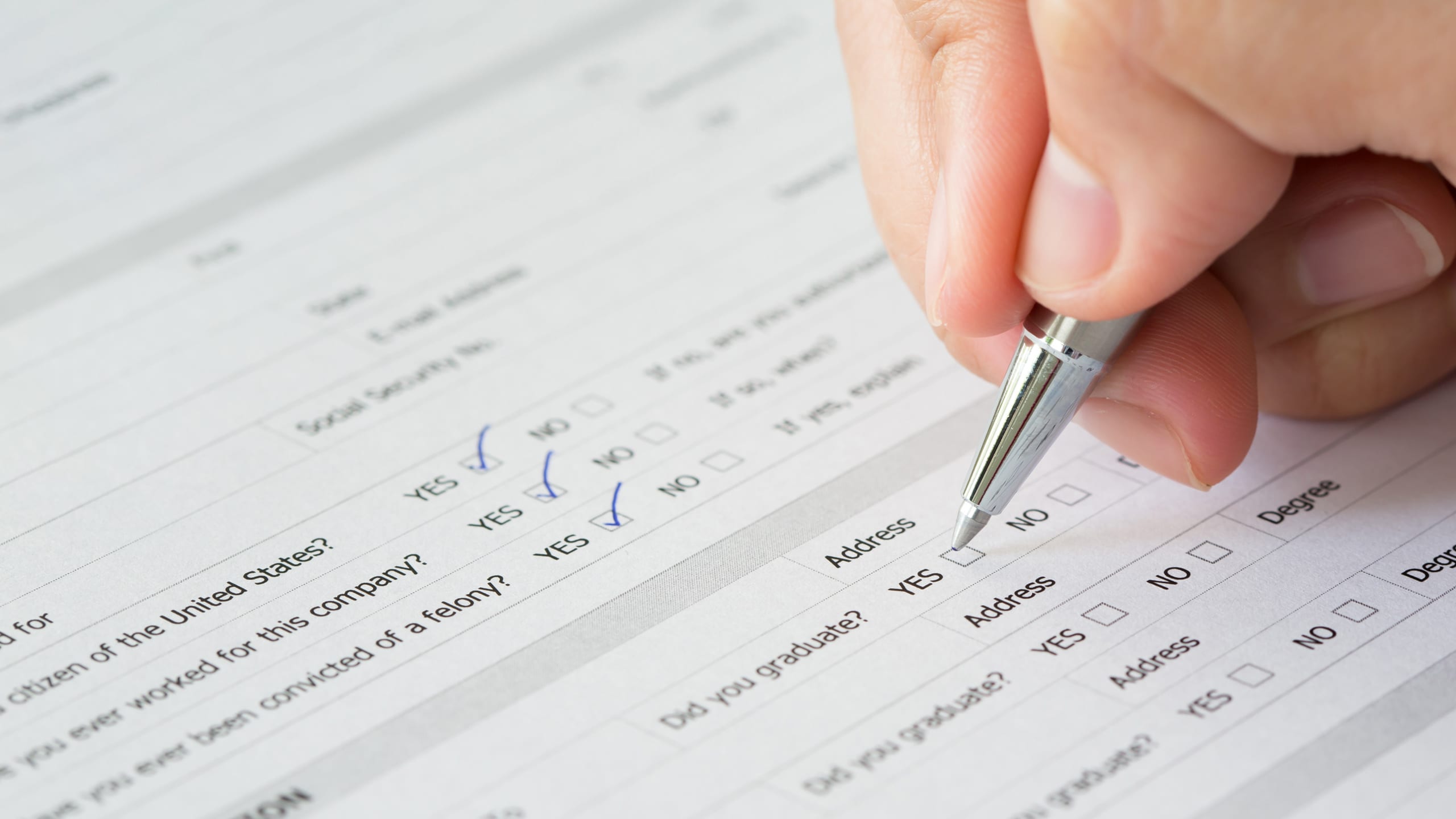A person filling up a form with a pen.
