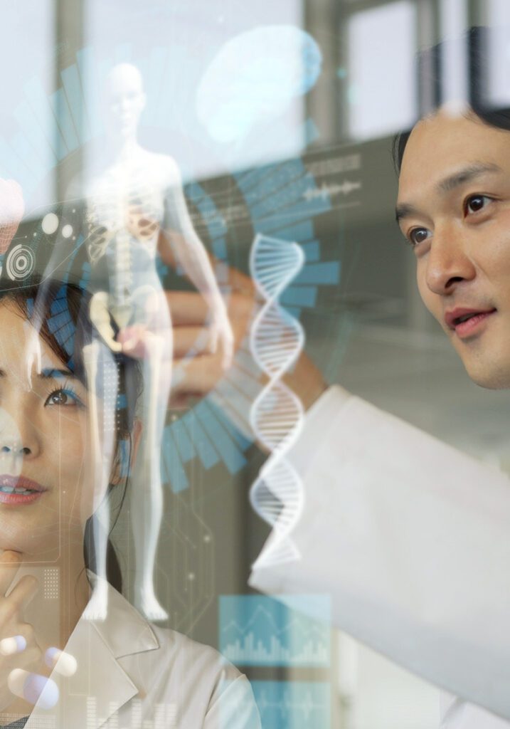 A male and female looking at a diagram of the human body projected onto a glass wall.