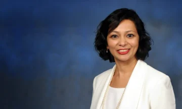 A headshot of Prajakta Mohile standing in front of a blue background.