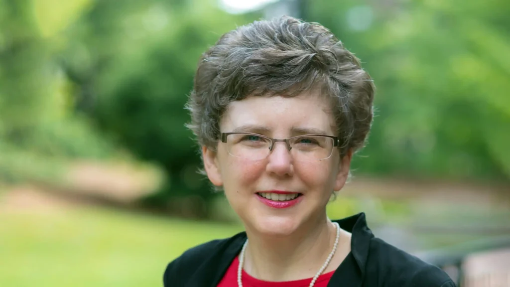 A headshot of Glenda Darrell standing outside with trees in the background.