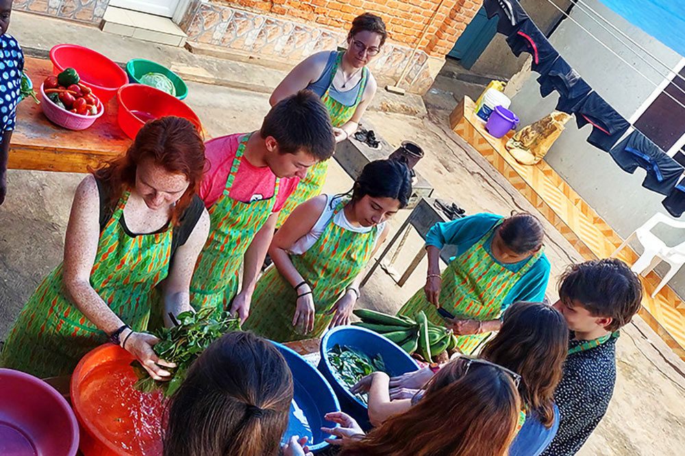 The group of students washing vegetables and preparing a meal