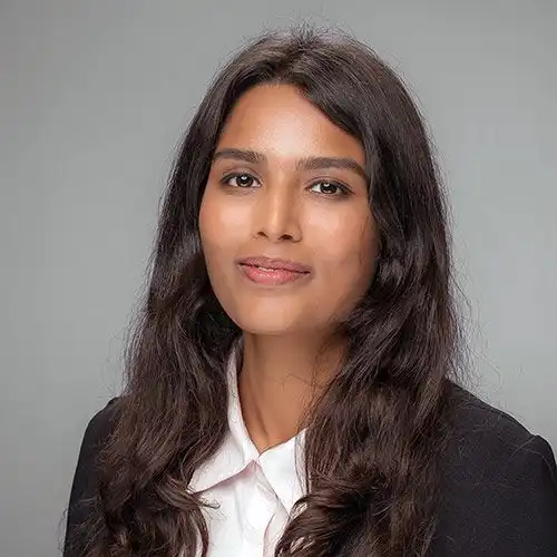 A headshot of MEMtor Hariyali Patel standing in front of a gray background.