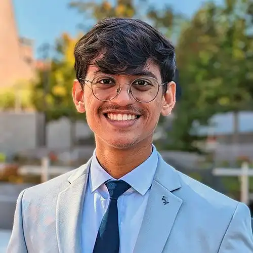 A headshot of MEMtor Jatin Chaudhari standing outside in front of some trees.