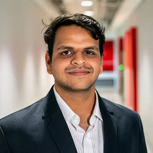 A headshot of Mrugank Joshi standing in a hallway within Fitts- Woolard Hall.