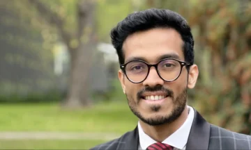 A headshot of Abhijay Shukla standing outside in front of some trees.