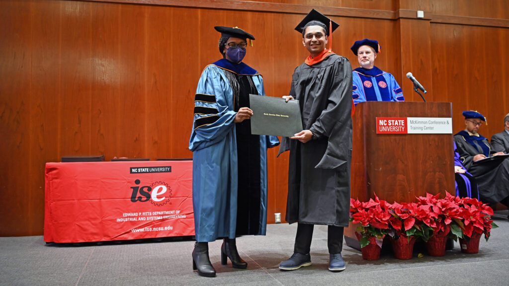 MEM student Kartik Khanderia receives his degree from the MEM director Julie Ivy on stage