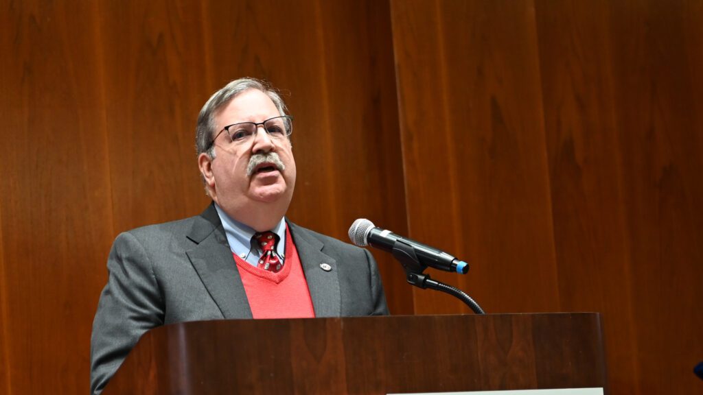 On stage, distinguished professor emeritus Paul Cohen delivers the commencement address