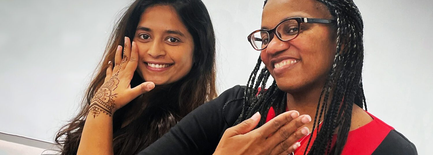 Julie Ivy and a MEM student showing off their new henna tattoos on their hands