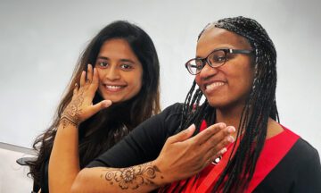 Julie Ivy and a MEM student showing off their new henna tattoos on their hands