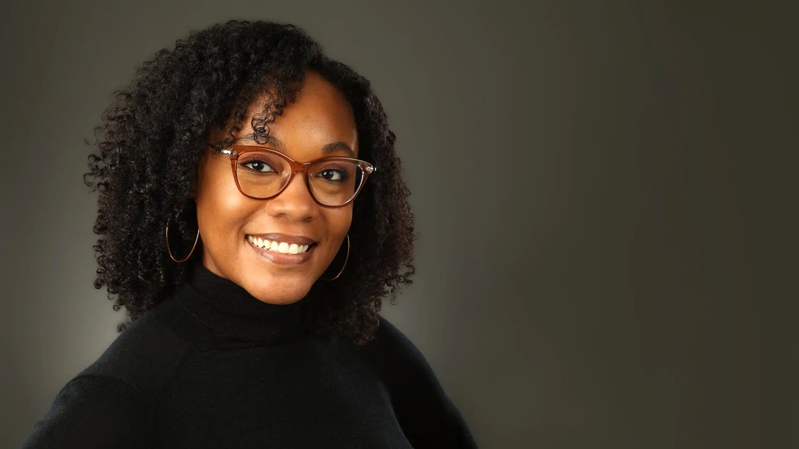 headshot of Natasha Wiley in front of a dark gray background.