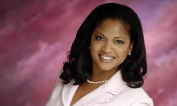 A headshot of Pamela McCauley standing in front of a pink and purple background.