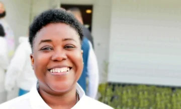 A headshot of Tammy Montgomery standing outside of a white building.