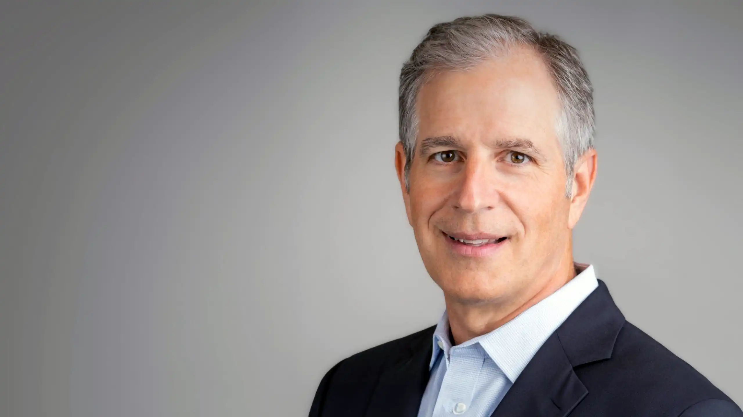 A headshot of Todd Grosshandler in front of a gray background.