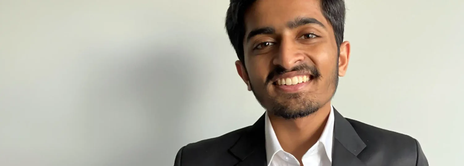 A headshot of Nisarg Dinesh Shah standing in front of a white background.