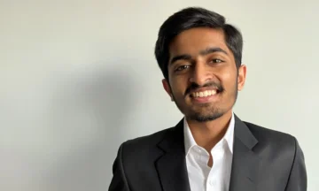 A headshot of Nisarg Dinesh Shah standing in front of a white background.