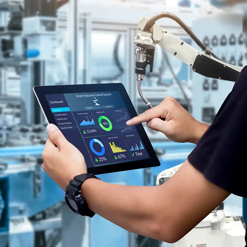 A student using a tablet to program a robot in an advanced manufacturing lab as part of their Master of Engineering Management degree at NC State University.