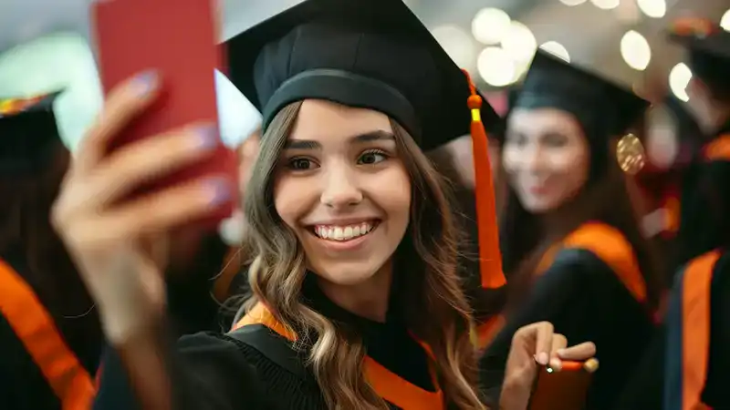 A woman taking a selfie after receiving her MEM degree from NC State University.