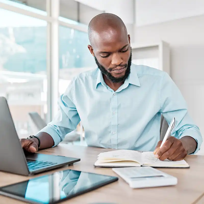 A student sitting at a laptop completing his online assignments for his Master of Engineering Management from NC State University. 