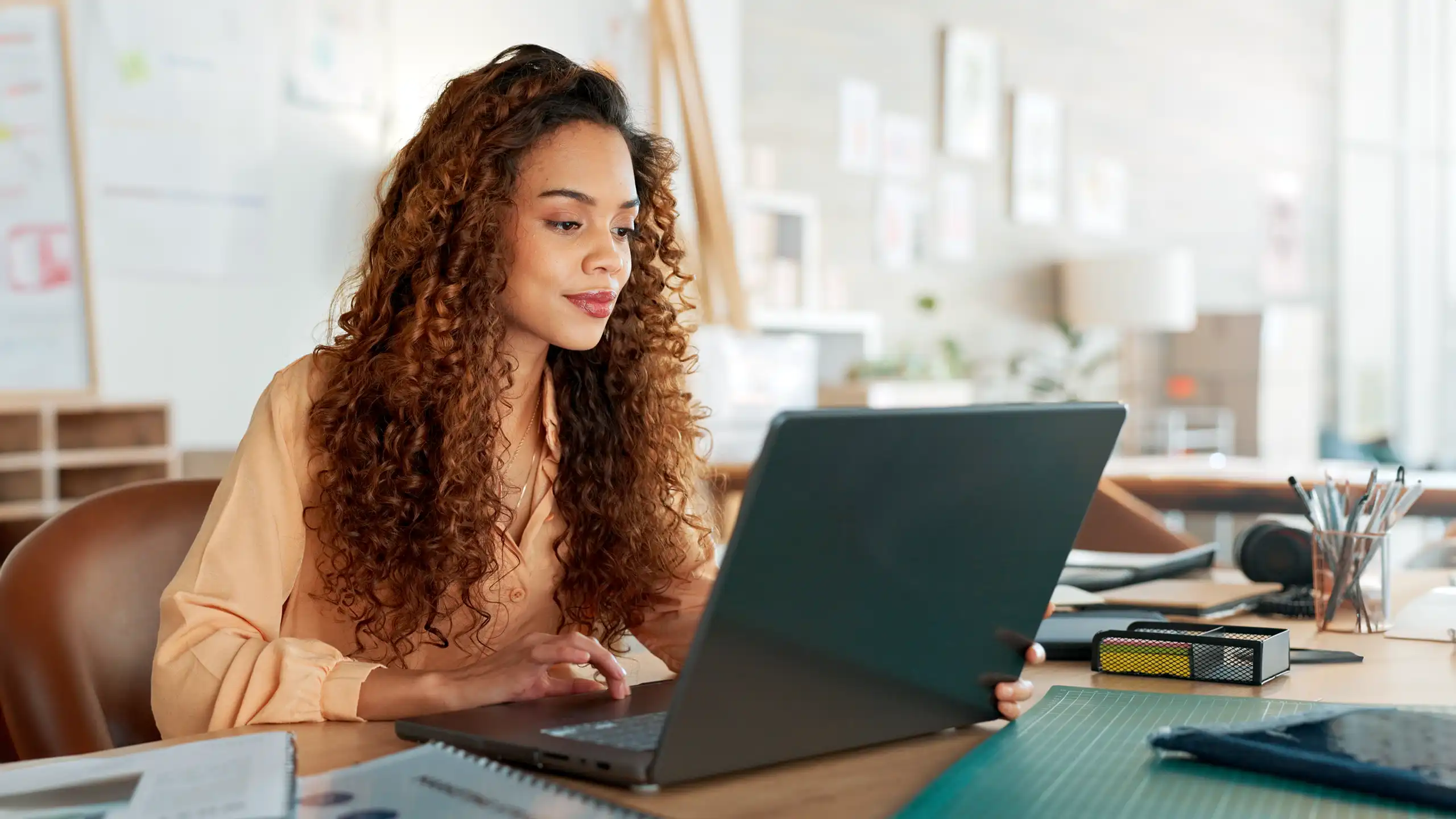 A student sitting at a laptop working on their online Master of Engineering Management degree.