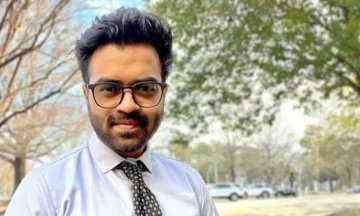 A headshot of Pavan Balekundri standing outside in front of a bunch of large trees.