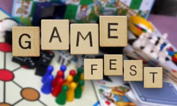 The words Game Fest spelled in Scrabble tiles floating over a background of game boards and pieces.