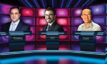 The three new faculty members are standing behind podiums on the set of a game show.