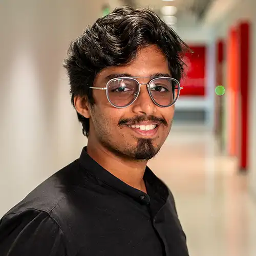 A headshot of MEMtor Vipin Varughese standing in front of a gray background.