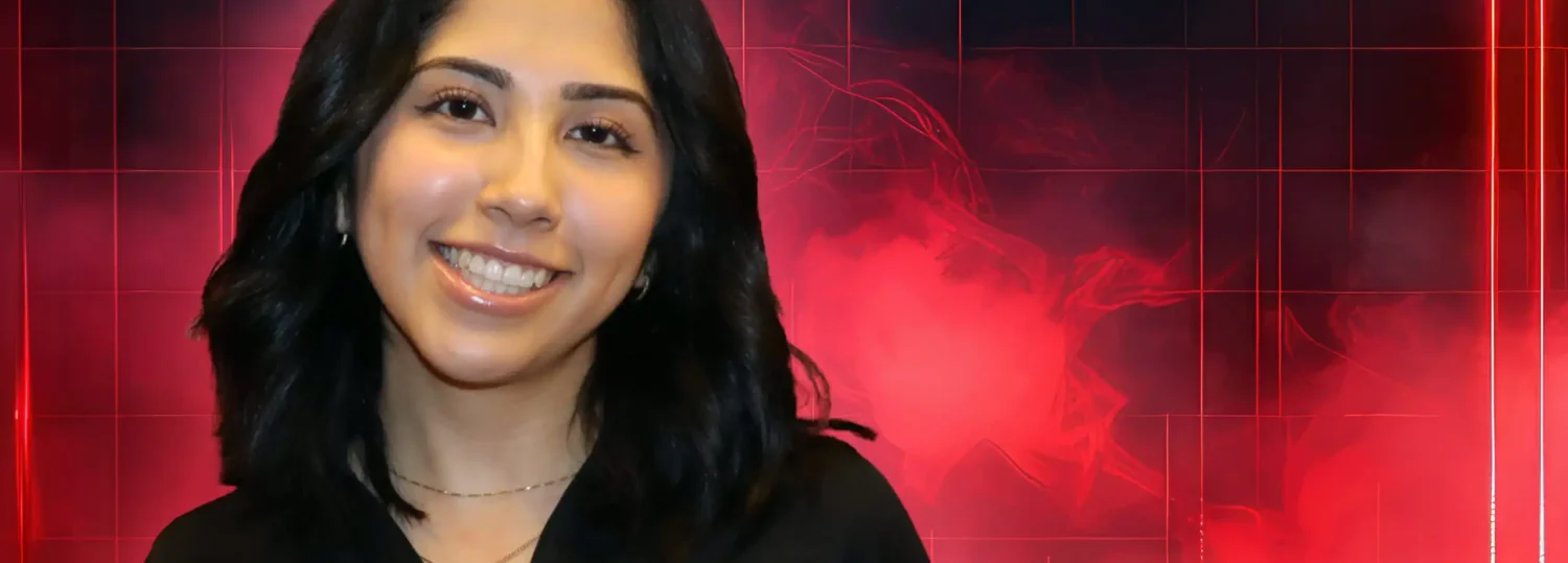 A headshot of Daniela Santibanez standing in front of a red and black abstract background.