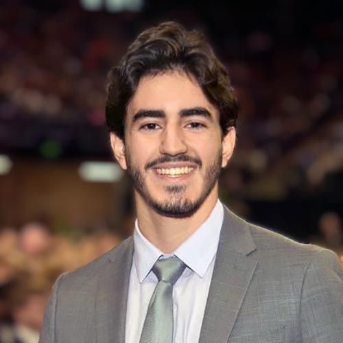 A headshot of MEMbassador Pedro Chaib standing in a large crowd at an indoor arena.