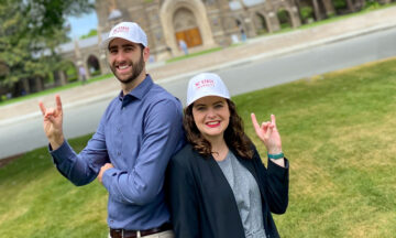 Tyler White and Melissa Pressley showing off their best "wolfie" while wearing their NC state baseball hats.