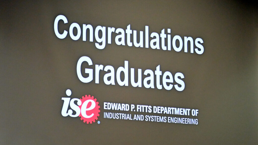 A congratulations message to the MEM graduates shown on a giant screen