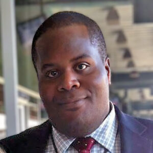 A headshot of Lee Jones standing outside of a building